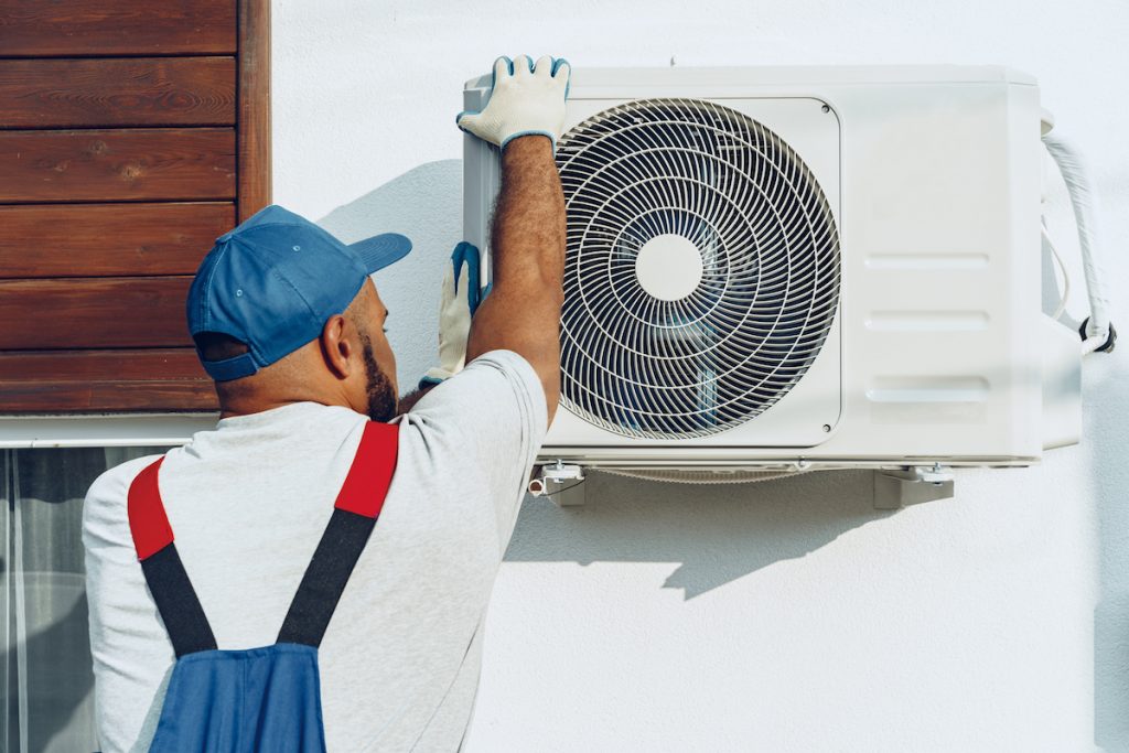 Here's Why Your Air Conditioner Isn't Working 2 Repairman fixing and air conditioner not blowing cold air.