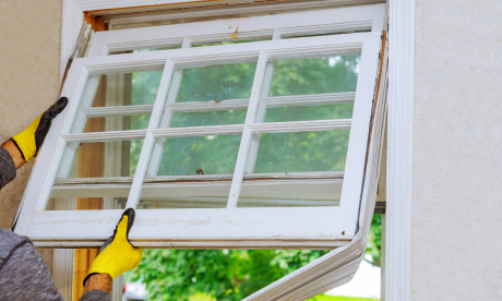 Main Home 17 A person's gloved hands replace an old window.