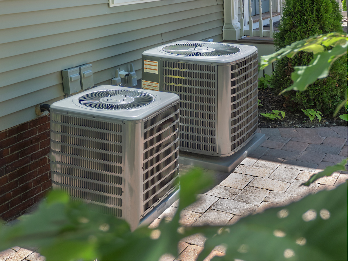 Two outdoor AC units next to one another on a brick floor. Average cost to replace ac unit in Florida.