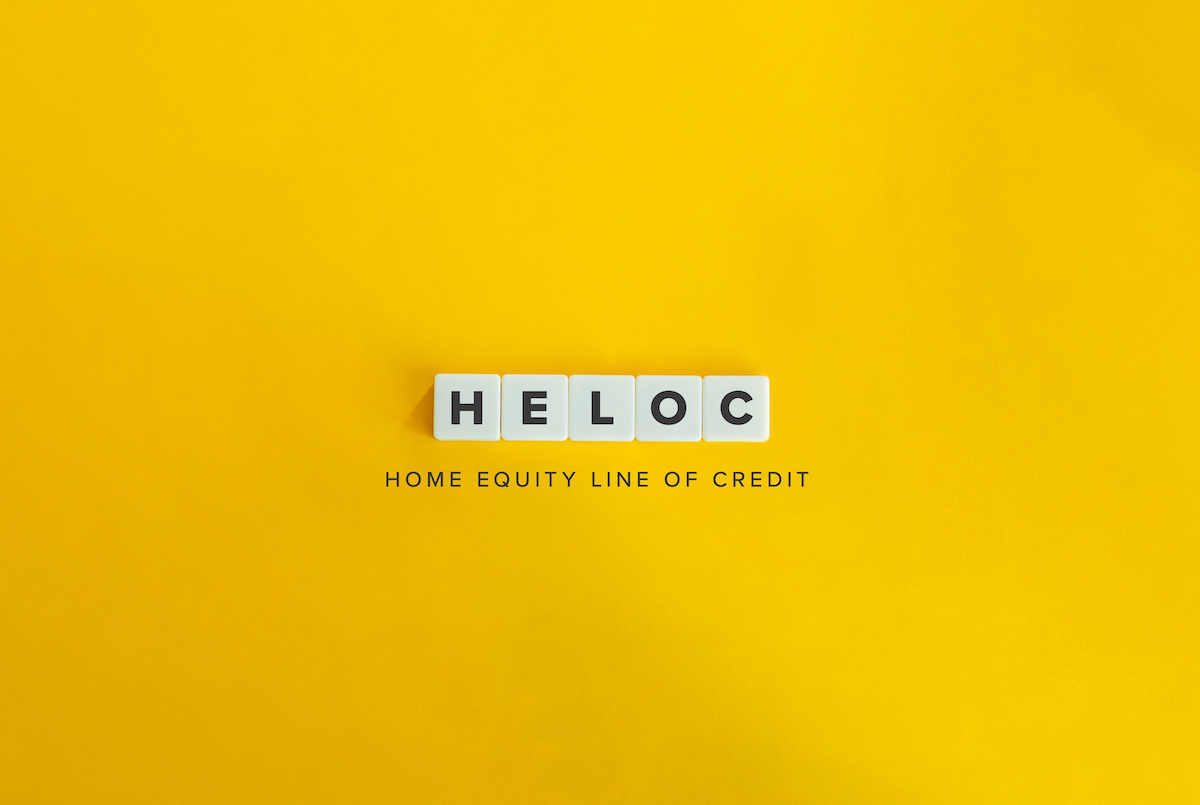 Scrabble letters that spell out "HELOC" on a yellow background.