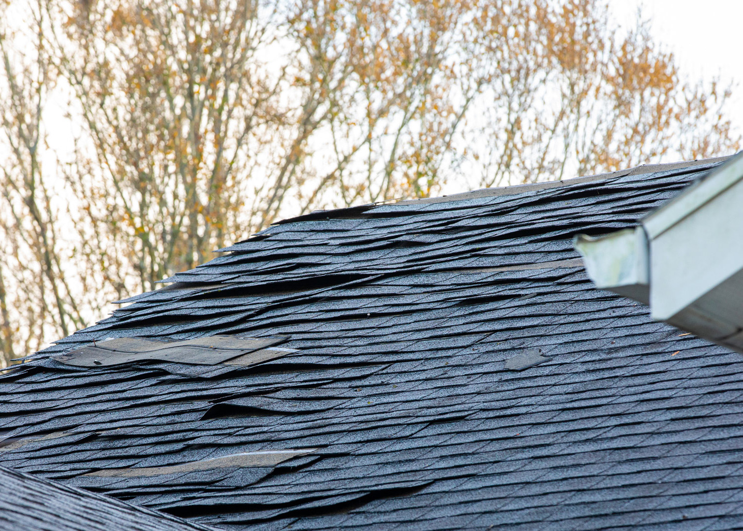 Damaged-roof Roof with shingles missing and torn up.