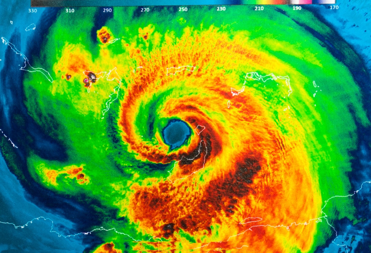 Satellite image of a hurricane with vibrant colors depicting different intensities, swirling towards a central eye.